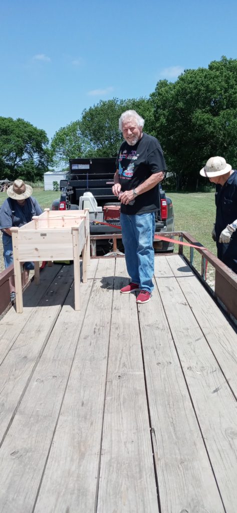 Brotherhood constructing elevated garden box for elderly members